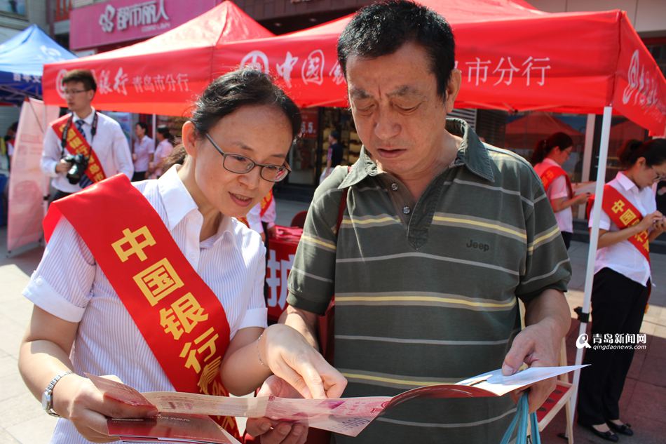 青岛开展反假币宣传，专业人员现场教市民辨别真假100元纸币